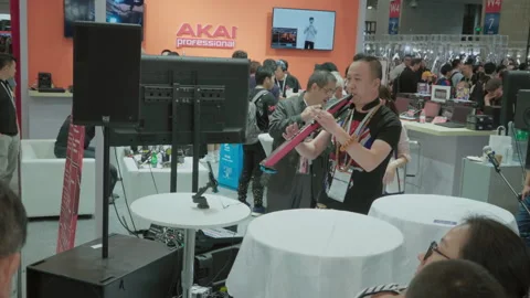 2019 Oct 13, Shanghai. Man demonstrates pink electronic wind instrument Stock Footage 345923104