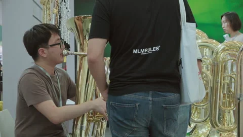 2019 Oct 13, Shanghai. Man tests large golden brass tuba Stock Footage 345925777