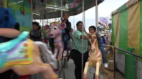 2019:SAN JOSE DEL CABO MEXICO.Children Riding Horses On A Carousel With Their Stock Photos