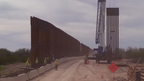 2020 Construction workers build Trumps immigration policy border wall or barrier Video stock 155841601