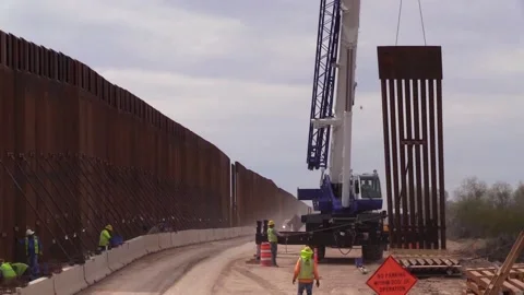 2020 Construction workers build Trumps immigration policy border wall or barrier Video stock 155841877