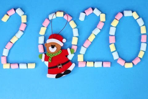 2020 is lined with colored marshmallows on a blue background. Happy New Year. Stock Photos