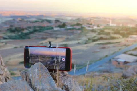 2020 red mobile smart phone trying to take a picture on mountain at the sunset Stock Photos