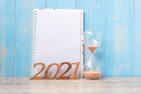 2021 Happy New Year  with blank notebook, Hourglass and wooden number. countd Stock Photos