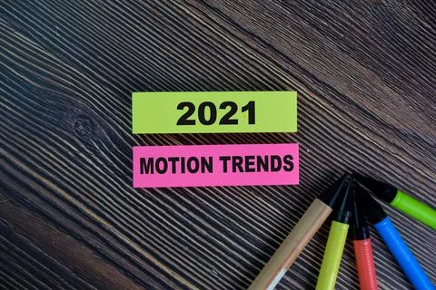 2021 Motion Trends write on sticky notes isolated on Wooden Table. Stock Photos