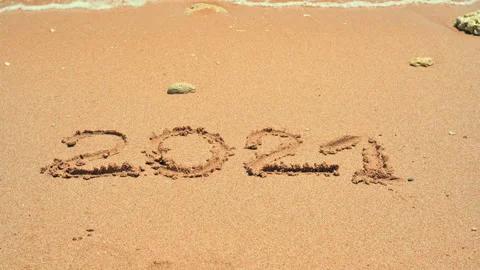 2021 written on the sand is getting washed away by the wave. 2021 is washed away Stock Footage 154651027