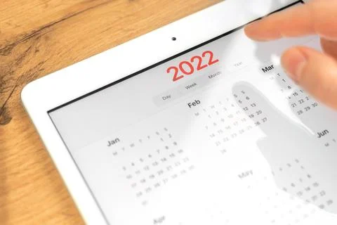 2022 calendar close-up, tablet computer screen. Business wooden table desktop Stock Photos