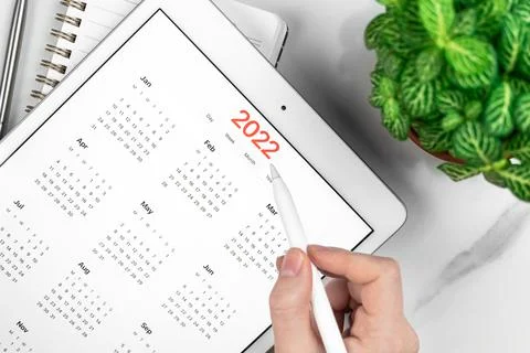 2022 calendar close-up, tablet computer screen. White marble background. Conc Stock Photos