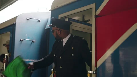 2023-06-01 - Nanu Oya, Sri Lanka. Bipoc train conductor waves green flag, gives Stock Footage 275095909