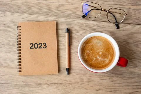 2023 notebook and coffee cup on wood table, Top view and copy space. Xmas, Ha Foto stock