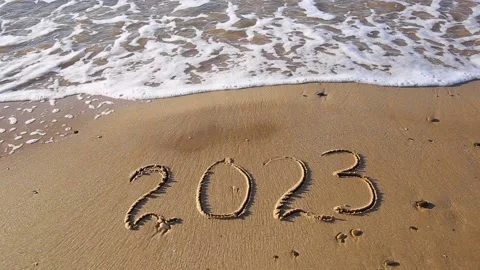2023 year written on sandy beach sea Stock Footage 220673544