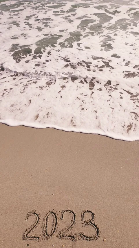 2023 year written on sandy beach sea at sunny day Stock Footage 233819155