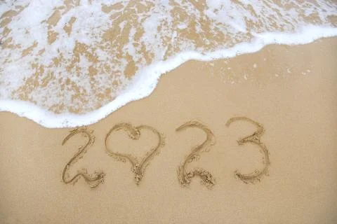2023 year written on sandy beach sea. Top view. Flat lay. Stock Photos