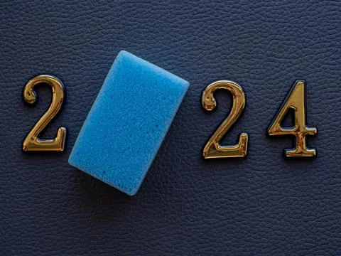 2024 and cleaning sponge instead zero on dark background Stock Photos