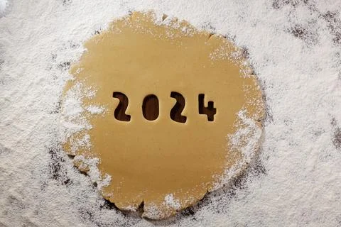 2024 numbers cut from rolled raw cookie dough on flour table Stock Photos