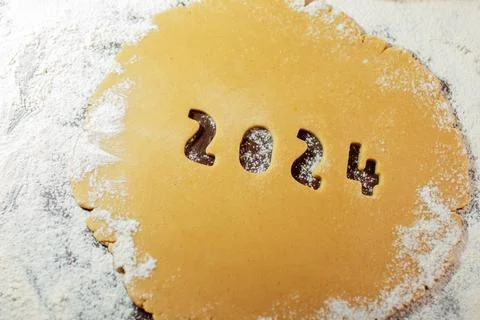 2024 numbers cut from rolled raw cookie dough on flour table Stock Photos