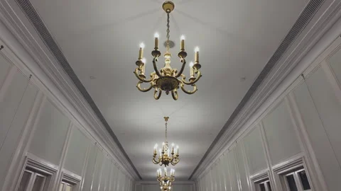 2024 Oct 6. Shanghai, Low angle of ornate chandeliers in paneled corridor Stock Footage 333495703
