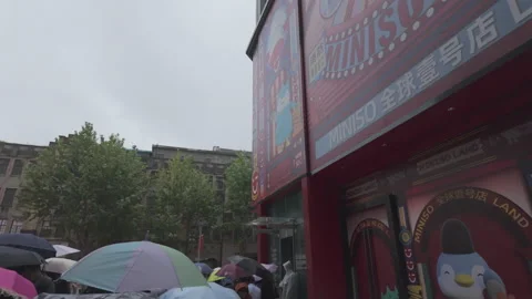 2024 Oct 7. Shanghai, Crowd queuing outside Miniso Land store in rain Stock Footage 333664412