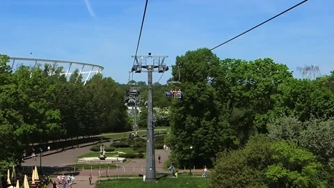 2025- 05-02; cable cars over the park with views of trees and people enjoying Stock Footage 329052337