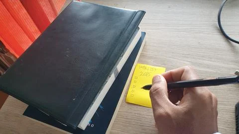 2025 resolution by writing a list using a black pen with a book background Stock Photos