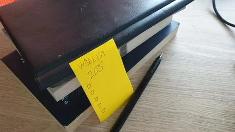 2025 resolution by writing a list using a black pen with a book background Stock Photos