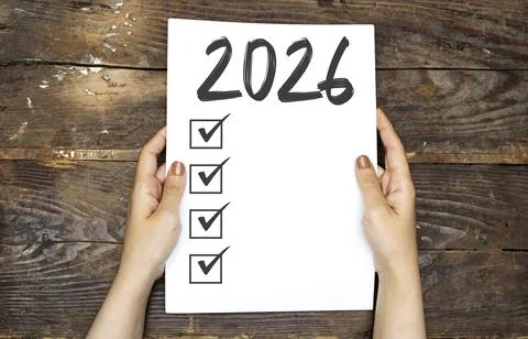 2026 Checklist Document Held By Hands Over Rustic Wood Table For Planning And Go Stock Photos