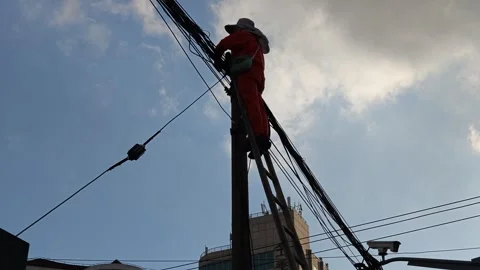 2026 Jul 25, Shanghai. Low angle backlit view of utility worker repairing Stock Footage 344740950