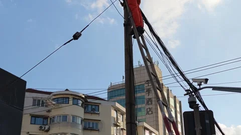 2026 Jul 25, Shanghai. Utility worker climbs wooden ladder to maintain Stock Footage 344740959
