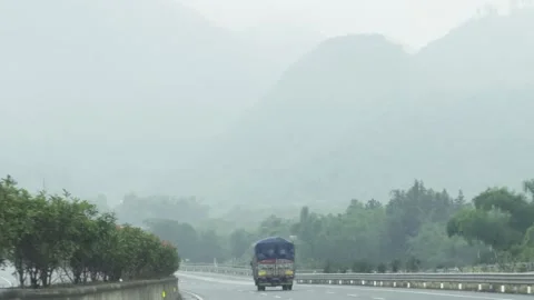 2026 Jun 06, Guangzhou. Car Carrier Truck Drives Away On Wet Highway Under Stock-Footage 335579025