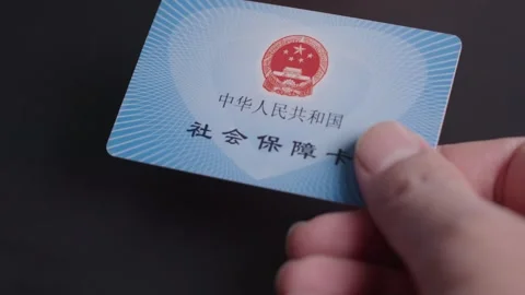 2026 Jun 09, China. Hand Holding Chinese Social Security Card Against Dark Vídeos de archivo 336545111