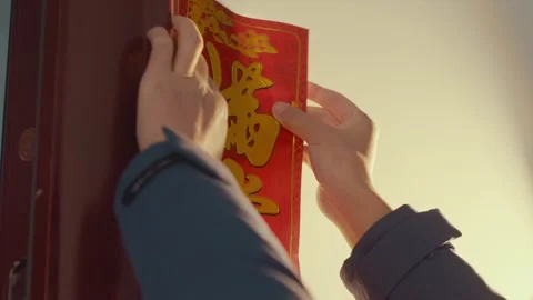 2026 Jun 09, China. Man in Blue Suit Pressing Red Lunar New Year Door Ornament Stockbeeldmateriaal 336560998