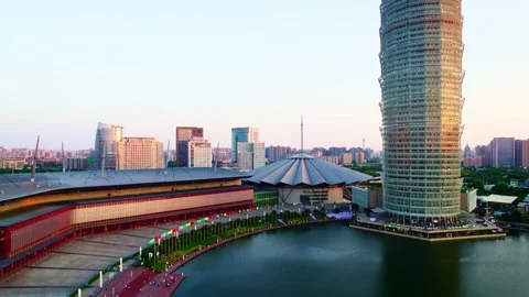2026 Jun 09, Zhengzhou. Tiny Figures Walk Along Waterfront Promenade Near Stock Footage 336527090