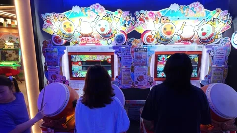 2026 Jun 29, Shanghai. Group plays Japanese taiko drum rhythm arcade game Stock Footage 337880074