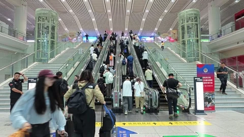 2026 Jun 30, Shanghai. Travelers on transit station escalators Stock Footage 338232103