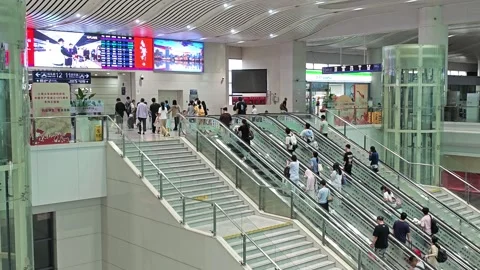 2026 Jun 30, Shanghai. Wide shot of travelers moving on escalators Stock Footage 338231927