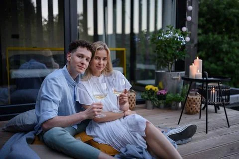 A young couple clinking with wine outdoors, weekend away in tiny house in countryside, sustainable living. xkwx love, wine, couple, woman, man, outdoor, happy, terrace, romance, romantic, together, young, drink, glass, person, smiling, caucasian, celebration, lifestyle, garden, party, relationship, two, alcohol, cheerful, vacation, tourism, closeness, date, honeymoon, newlyweds, lover, positive, togetherness, drinking, champagne, evening, holding, tiny house, holiday, nature, off beat, relax, meditation, digital detox, candle, hygge, travel, weekend away