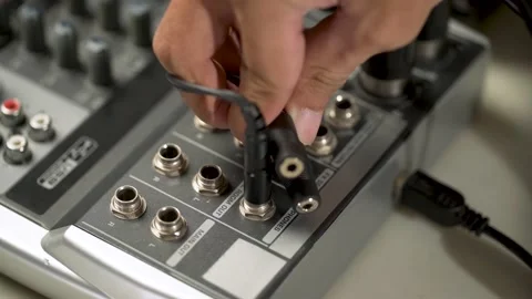 20_close-up hand plugging a cable into the sound or audio mixer Video stock 156028670