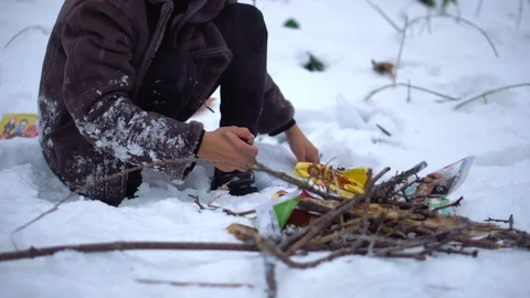 20s Asian Man Making Fire in Cold Winter Forest on Snow Stock Footage 105498047