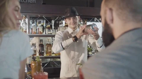 20s bartender is preparing cocktail with shaker behind guests Stock Footage 75238643