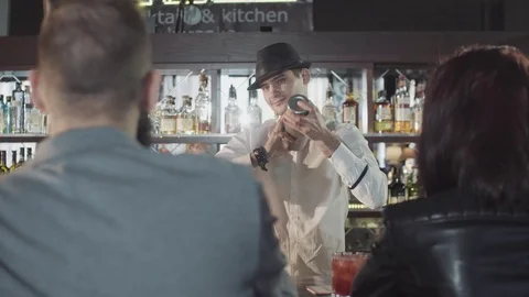 20s bartender is preparing cocktail with shaker behind guests Stock Footage 75238711