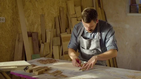 20s bearded carpenter drawing in workshop in sunny day Stock Footage 76105295