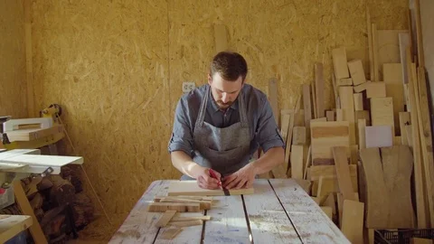 20s bearded carpenter drawing in workshop in sunny day Stock Footage 76106567