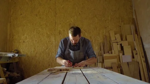 20s bearded carpenter drawing in workshop in sunny day Stock Footage 76106950