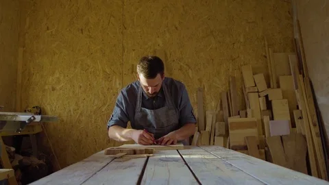 20s bearded carpenter drawing in workshop in sunny day Stock Footage 76107404