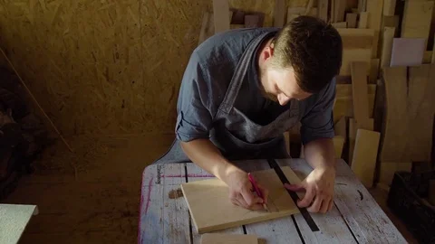 20s bearded carpenter drawing in workshop in sunny day Stock Footage 76107618