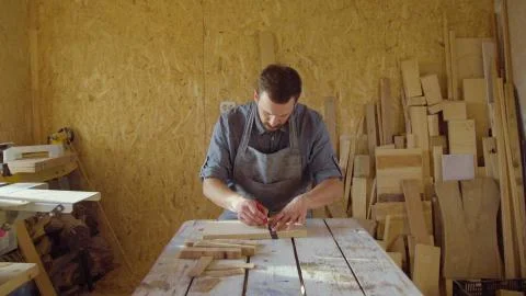 20s bearded carpenter drawing in workshop in sunny day Stock Photos