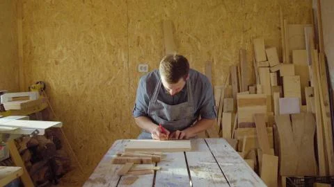 20s bearded carpenter drawing in workshop in sunny day Stock Photos