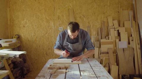20s bearded carpenter drawing in workshop in sunny day Stock Photos
