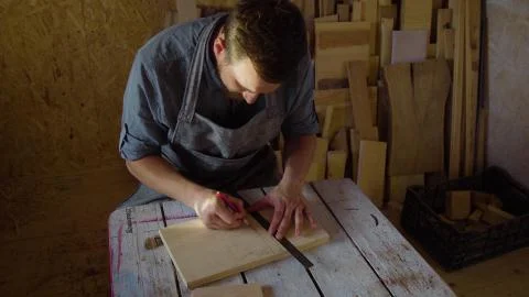 20s bearded carpenter drawing in workshop in sunny day Stock Photos