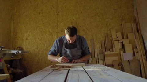 20s bearded carpenter drawing in workshop in sunny day Stock Photos